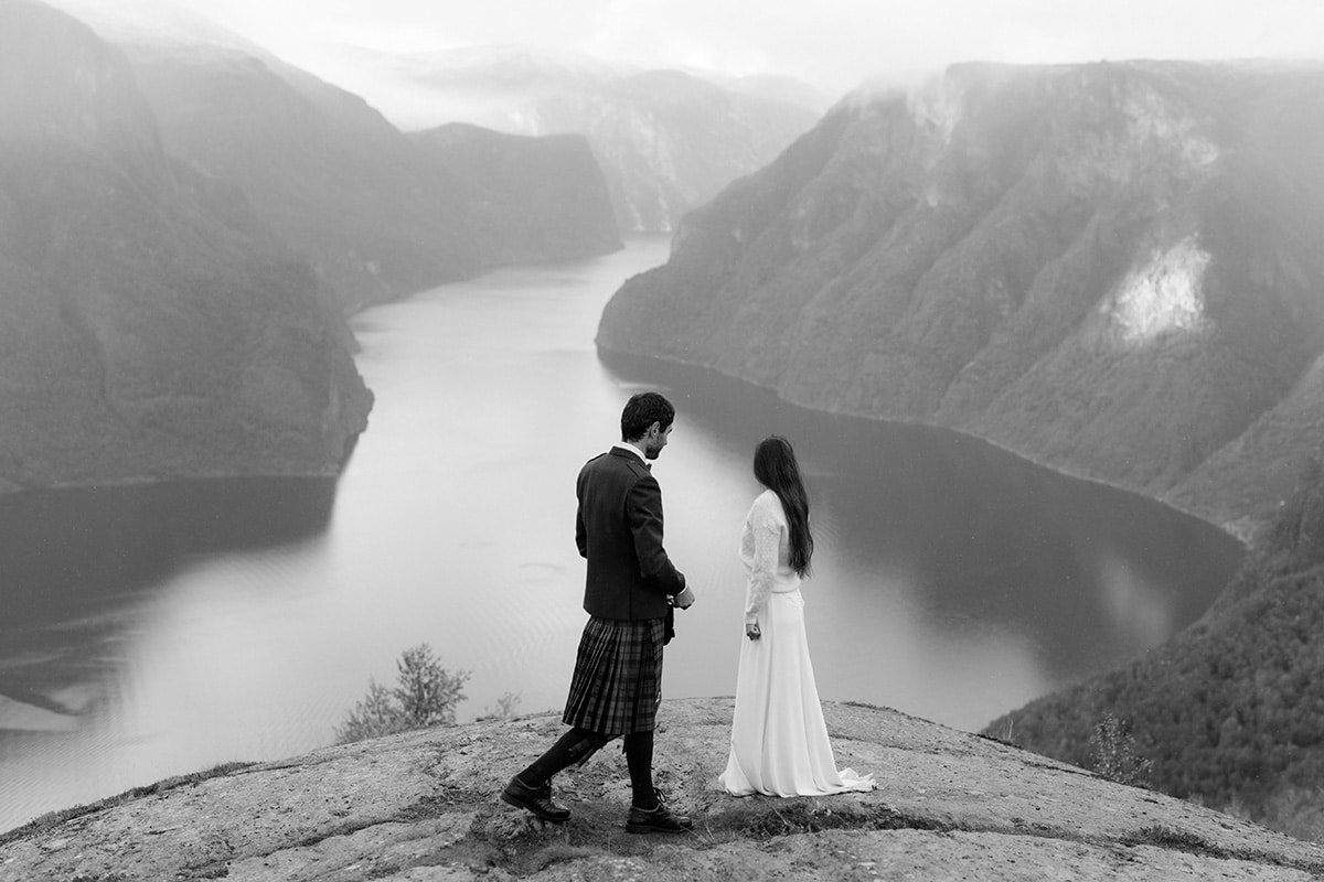 Bride and groom walking with a view of the fjord